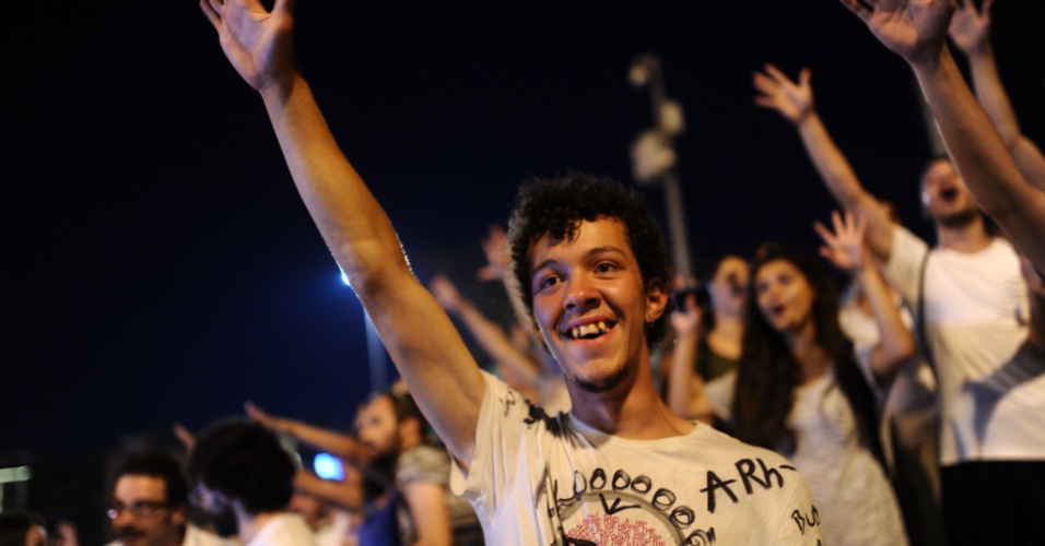 11.jul.2013 - Manifestantes contrários ao governo turco gritam palavras de ordem na entrada do parque Gezi, na prala Taksim, em Istambul, na Turquia. O parque símbolo dos protestos antigovernamentais no país foi reaberto ao público na madrugada de segunda-feira (9)