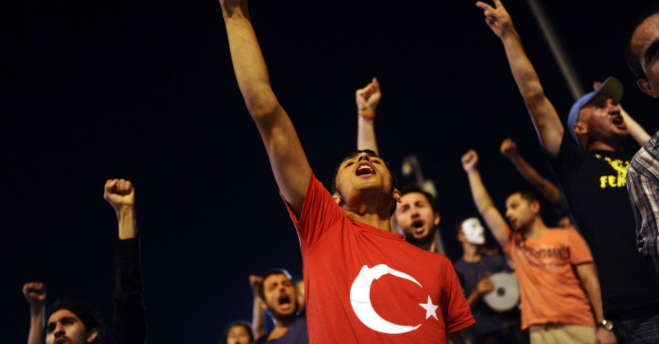 11.jul.2013 - Manifestantes contrários ao governo turco gritam palavras de ordem na entrada do parque Gezi, na prala Taksim, em Istambul, na Turquia. O parque símbolo dos protestos antigovernamentais no país foi reaberto ao público na madrugada de segunda-feira (9)