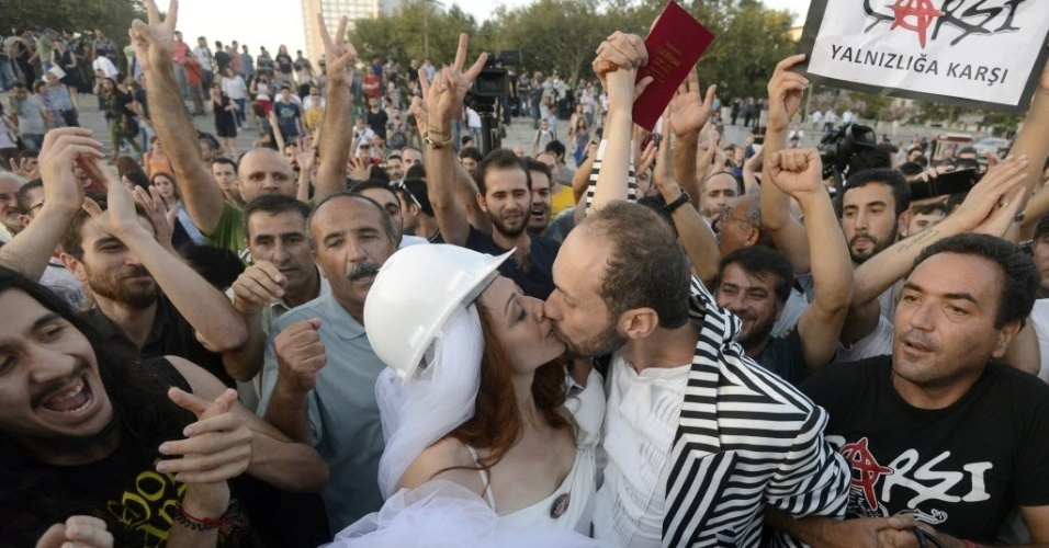 20.jul.2013 - O casal recém-casado, Nuray Cokol (esq.) e Ozgur Kaya (dir.) se beija no parque Gezi, loga após a cerimônia de casamento durante protesto contra o governo da Turquia, em Istambul, neste sábado (20). O casal se conheceu na ocupação do parque Gezi, em meios às manifestações que tiveram estopim no local e que varreram o país nos meses de maio e junho 