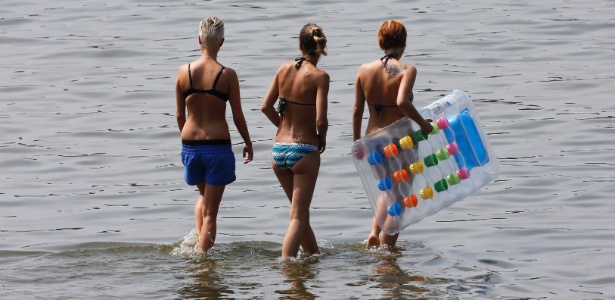 Mulheres caminham se refrescam no lago Wansee em Berlim, temperaturas chegam aos 30º C - Fabrizio Bensch/Reuters