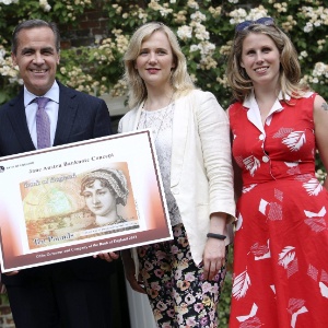 O presidente do Banco da Inglaterra, Mark Carney (esq.), posa junto com Caroline Criado-Pérez (primeira à dir.), com a imagem da nova nota de 10 libras que traz a escritora britânica Jane Austen. A novidade foi lançada no último dia 24 de julho    - EFE/Bloomberg 