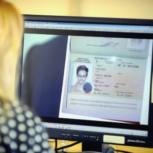Mulher observa imagem em computador do visto temporário concedido por Moscou a Edward Snowden - AFP