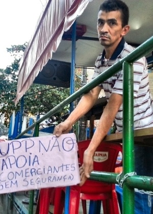 Comerciante da favela da Rocinha, que não quis se identificar, exibe cartaz protestando contra a UPP local - Hanrrikson de Andrade/UOL