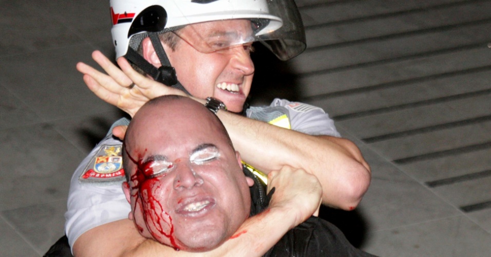2.jul.2013 - Policial militar imobiliza manifestante ferido durante protesto contra os governos de São Paulo e Rio, em frente à Alesp (Assembleia Legislativa de São Paulo), na noite desta sexta-feira (2)