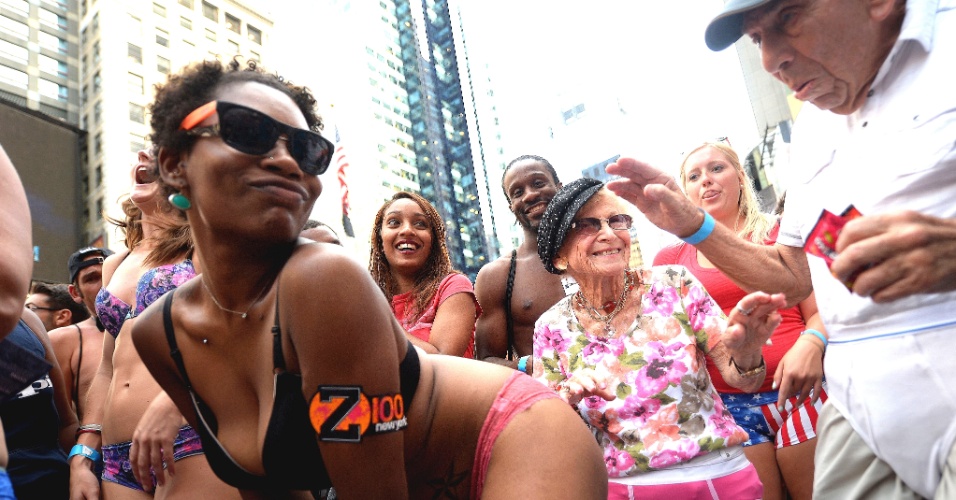 5.ago.2013 - Homem observa mulher dançar de roupas íntimas, durante evento em Nova York buscando quebrar o recorde de maior número de pessoas em roupas íntimas reunidas no mesmo local. Os organizadores esperam superar a marca de 2.270 pessoas em Times Square, no centro de Nova York