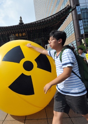 Ativistas contra a energia nuclear marcham acompanhados de balão com o símbolo de alerta radioativo em protesto  - Jung Yeon-Je/AFP