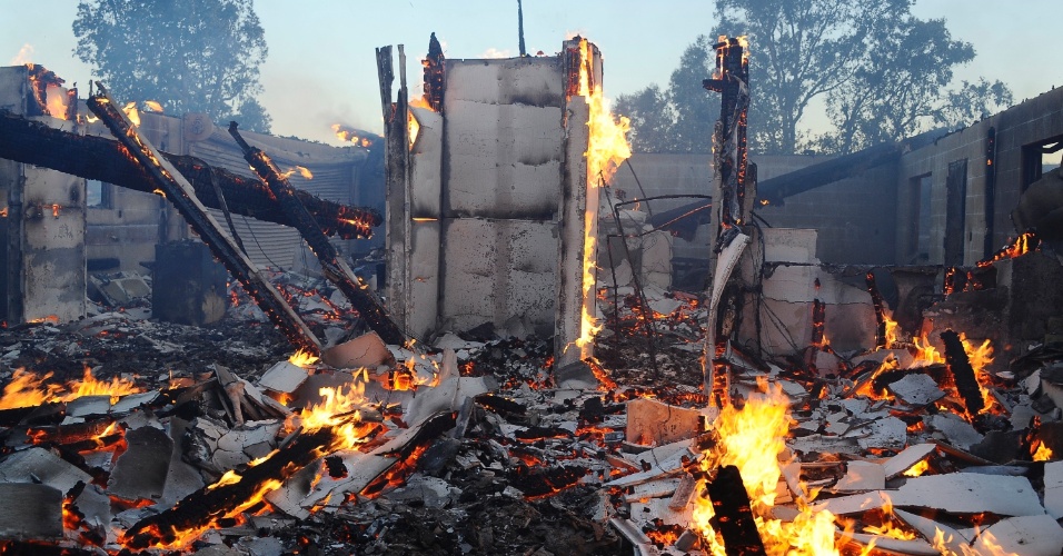 8.ago.2013 - Escombros de casa destruída por incêndio florestal de grandes proporções que atinge área de 5.000 hectares de terra perto de Banning, a 90 km de Los Angeles, na Califórnia (EUA), na manhã desta quinta-feira (8)