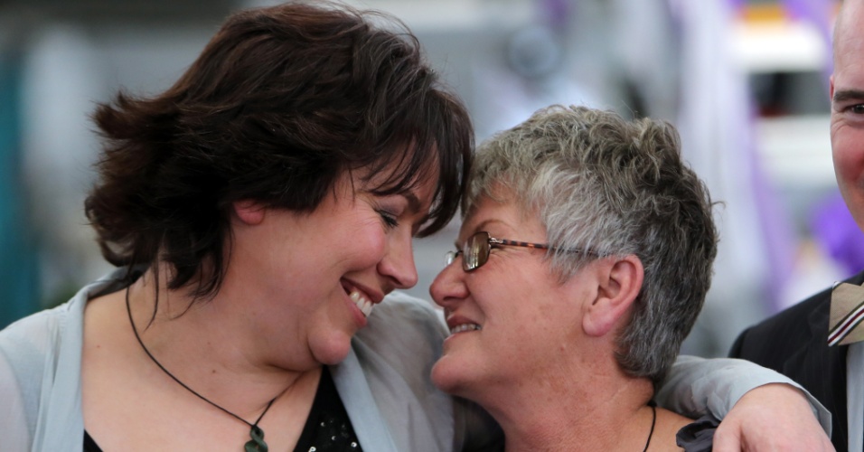 19.ago.2013 - Lynley Bendall e Ally Wanikau se abraçam nesta segunda-feira (19) após se casarem em cerimônia coletiva em Auckland, Nova Zelândia. Nesta segunda, o casamento homossexual foi legalizado no país, o 17º do mundo a tornar legal a união. A Nova Zelândia descriminalizou a homossexualidade em 1986 e desde 2005 permitia as uniões civis entre pessoas do mesmo sexo