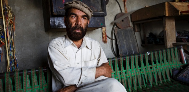 Matiullah Turab, um dos mais famosos poetas pashtuns do Afeganistão, na garagem onde ganha a vida consertando os coloridos caminhões de caravana paquistaneses - Christoph Bangert/The New York Times