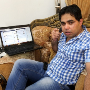 Hacker palestino Khalil Shreateh posa ao lado de seu computador, na cidade de Yatta, Cisjordânia. Ele teria invadido o perfil de Mark Zuckerberg na rede social para alertar o dono da página de que havia descoberto uma falha na página - Abed Al Hashlamoun/Efe