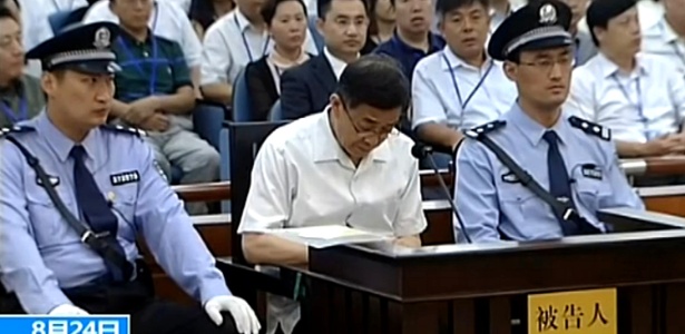 Imagem extraída da transmissão da rede estatal de TV chinesa mostra o ex-dirigente do partido Comunista Bo Xilai escrevendo durante seu julgamento - 24.ago.2013 - CCTV/AFP