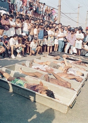 Moradores observam corpos de vítimas da chacina de Vigário Geral, que resultou na morte de 21 pessoas na noite de 29 de agosto de 1993 - Zeca Guimarães/Folhapress - 30.ago.1993