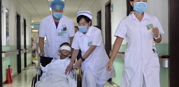 Guo Bin, garoto que teve os globos oculares arrancados em um suposto caso de tráfico de órgãos, é conduzido em cadeira de rodas por equipe médica de hospital em Taiyuan, na província chinesa de Shanxi - Yu Ji China/Efe/Epa