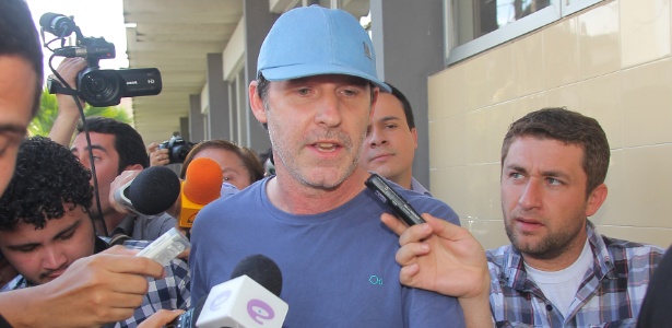 Eduardo Gaievski (de boné azul) chega ao 3º Distrito Policial de Curitiba; ele diz que não abusou de jovens - João Carlos Frigério/Estadão Conteúdo