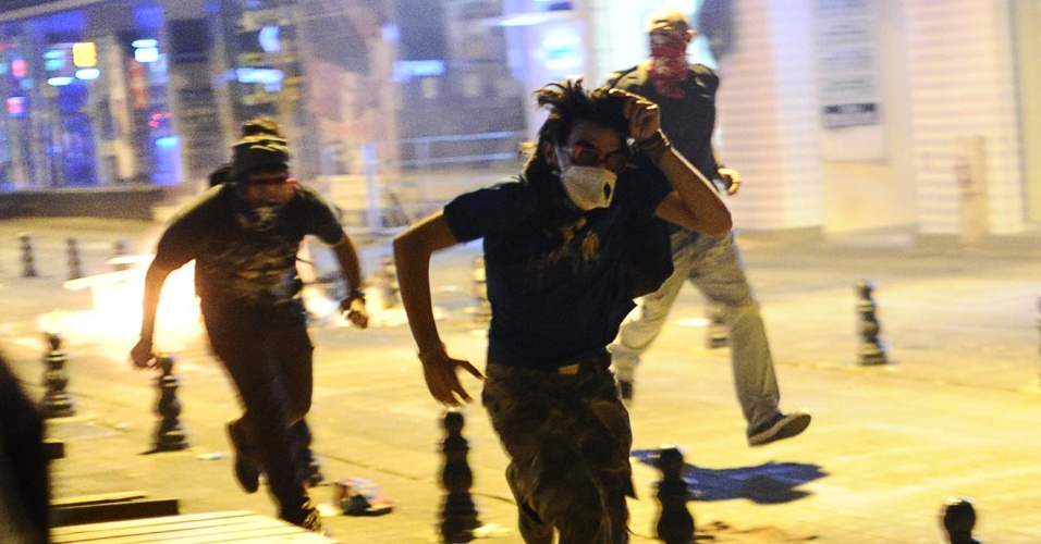 12.set.2013 - Manifestantes correm durante protesto contra a repressão policial que resultou na morte de jovem de 22 anos, em Kadikoy, em Istambul (Turquia), nesta quinta-feira (12)