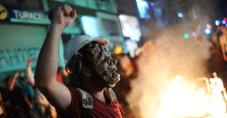 12.set.2013 - Mascarado grita palavras de ordem durante protesto contra a repressão policial que resultou na morte de jovem de 22 anos no sul da Turquia, em Kadikoy, em Istambul (Turquia), nesta quinta-feira (12)