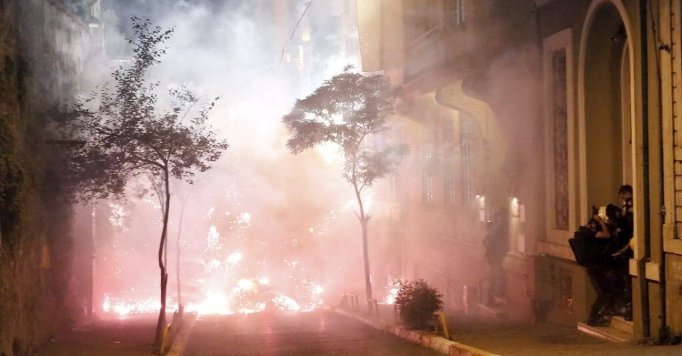 14.set.2013 - Manifestantes tentam se proteger de gás lacrimogêneo lançado pela polícia turca durante protesto contra o governo, em Istambul (Turquia), neste sábado (14)