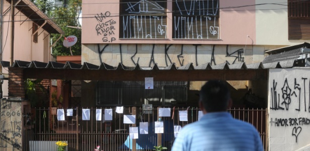 Casa onde mulher teria matado as duas filhas e tentado suicídio, no Butantã, zona oeste de São Paulo, amanheceu pichada e com cartazes e flores espalhados pelo portão nesta segunda-feira (16) - Gabriela Biló/AE