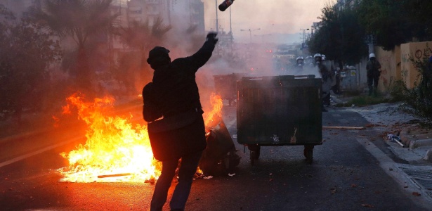 Manifestante arremessa coquetel molotov contra a polícia durante protesto organizado após o assassinato do rapper antirracismo Pavlos Fyssas, 34, morto por um neonazista