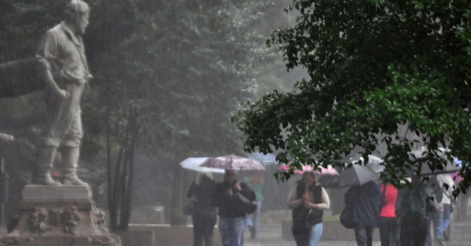 19.set.2013 - Paulistanos se protegem da chuva na avenida Paulista, região central de São Paulo, na manhã desta quinta-feira (19)
