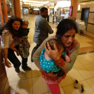 Mulheres saem com crianças no colo após ataque em shopping de Nairóbi, no Quênia