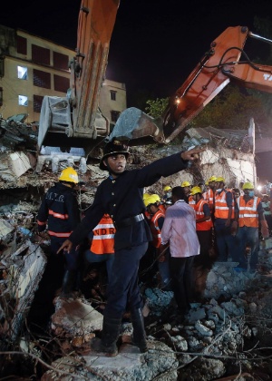 28.set.2013 - Socorrista pede maca para resgatar sobreviventes durante trabalho de buscas por entre destroços de prédio de cinco andares que desabou em Mumbai (Índia) - Danish Siddiqui/Reuters