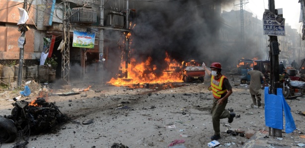 Socorrista trabalha em local onde uma bomba caiu neste domingo  - Hasham Ahmed/AFP
