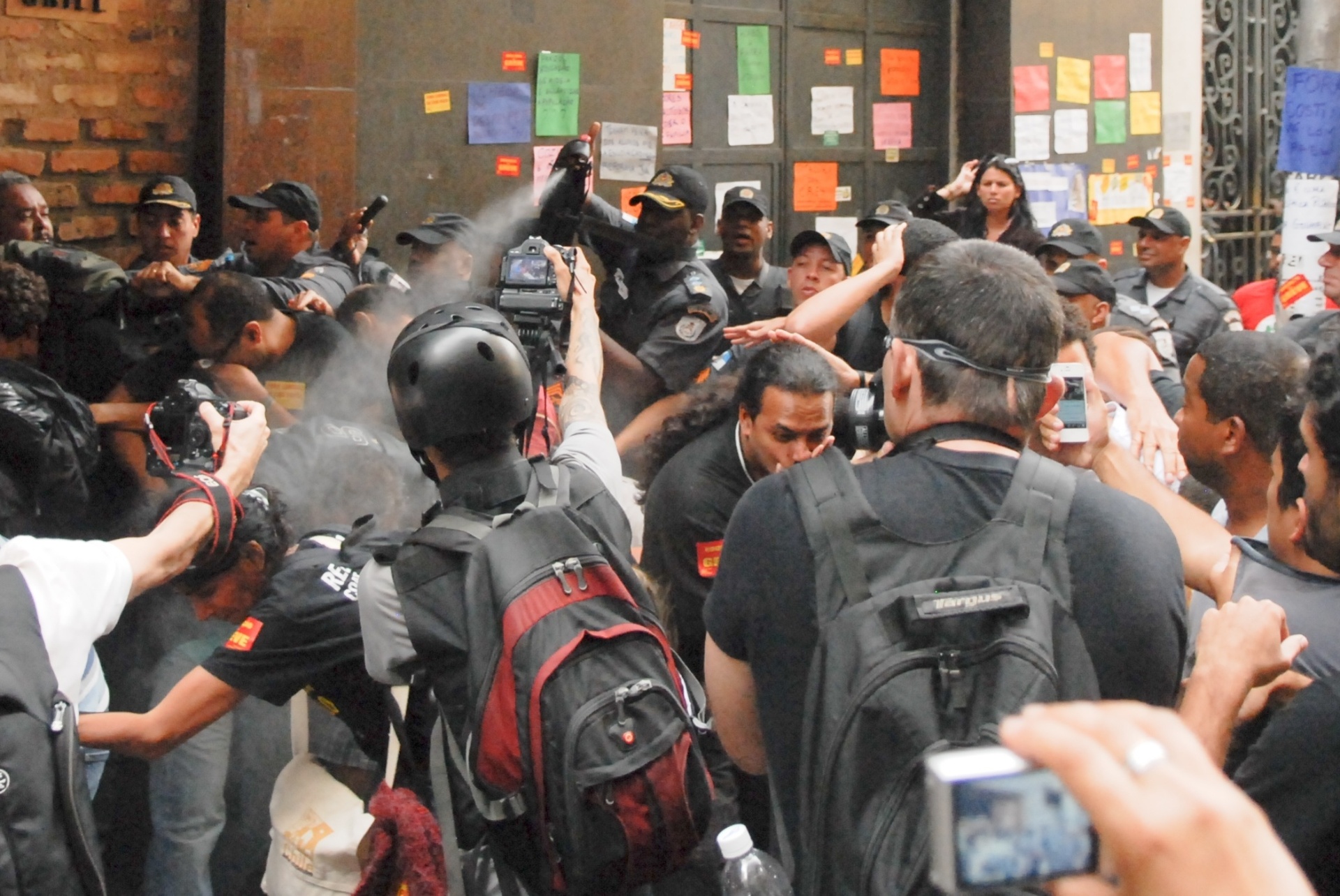30.set.2013 - Polícia Militar usa spray de pimenta durante protesto dos professores do lado de fora da Câmara dos Vereadores, no centro do Rio. Segundo o sindicato da categoria, os profissionais tentam entrar no prédio para um encontro com o líder do governo na Câmara, Luiz Antônio Guaraná. Eles pedem a suspensão da votação do projeto sobre o plano de carreira da categoria, que está na pauta de terça (1º) da Casa - Armando Paiva/Fotoarena/Estadão Conteúdo
