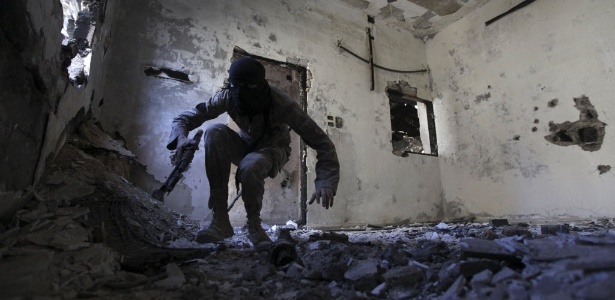 30.set.2013 - Rebelde sírio monta guarda em casa destruída de Deir al-Zor, na Síria. O chanceler Walid Muallem disse na ONU que seu governo aceita comparecer a uma conferência de paz em Genebra "sem pré-condições" - Khalil Ashawi/Reuters
