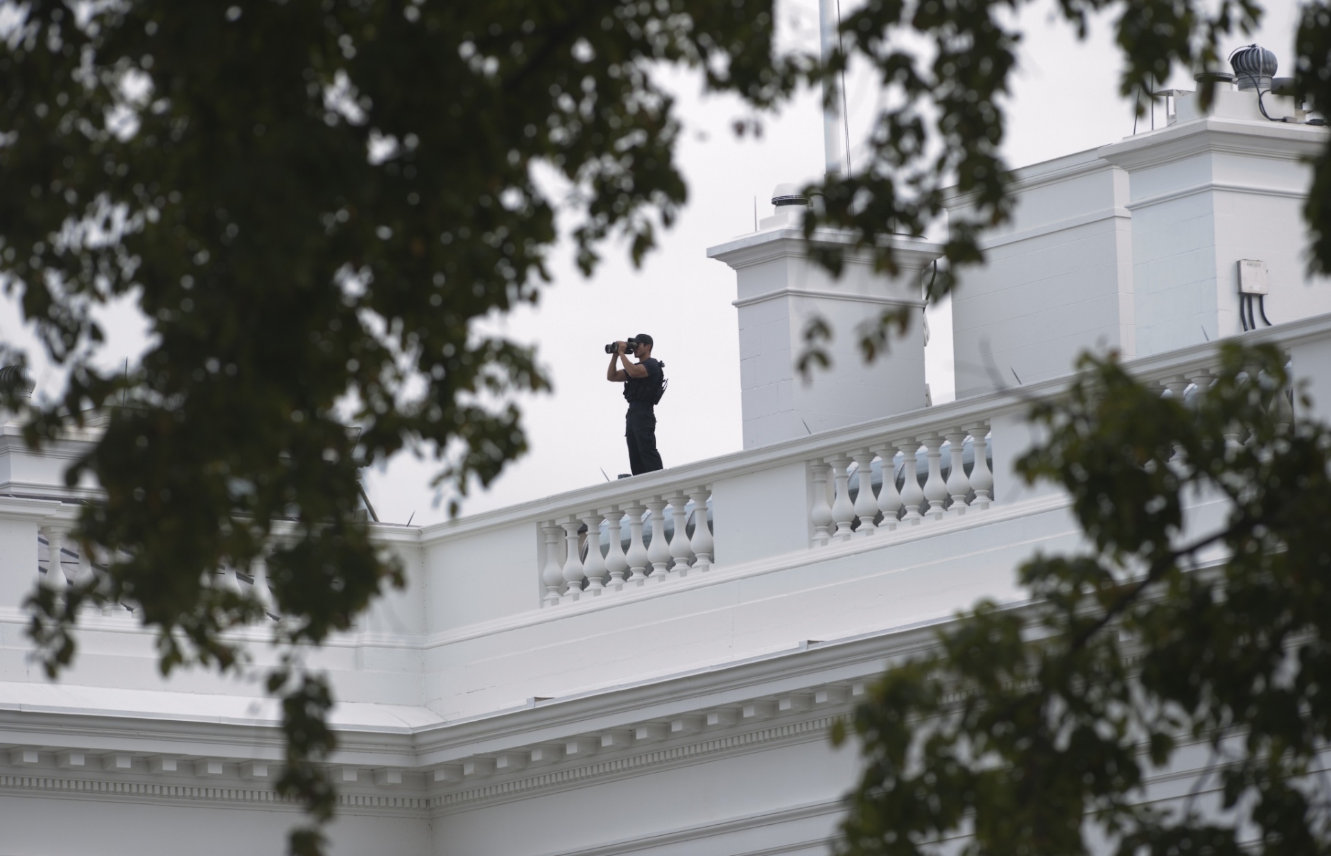 3.out.2013 - Um membro do serviço secreto norte-americano observa os arredores do Lafayette Park da cobertura da Casa Branca, em Washington, nesta quinta-feira (3), após tiros terem sido ouvidos do lado de fora do Capitólio - Saul Loeb/AFP