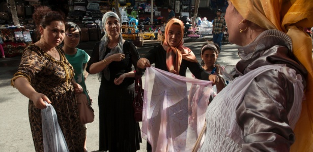 Mulheres fazem compras em mercado próximo a bairro uigure na China. Os uigures, um povo muçulmano de língua turca, enfrentam políticas repressivas em uma sociedade desconfiada que cada vez mais os encara como propensos ao extremismo religioso - Gilles Sabrie/The New York Times