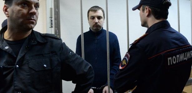 O ativista russo Mikhail Kosenko assiste ao seu julgamento em Moscou de dentro de uma jaula. Kosenko foi preso durante protesto em Moscou em 6 de maio de 2012, véspera da posse de Putin em seu novo mandato - Vasily Maximov/AFP