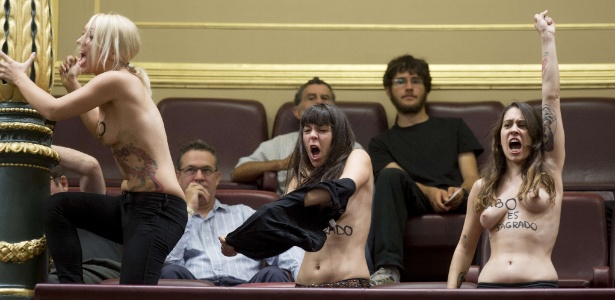 Membros do grupo ativista Femen fazem ato pró-aborto dentro do Congresso Nacional espanhol, em Madri, nesta quarta-feira (9). O presidente da câmara, Jesus Posada, determinou a retirada das ativistas depois de elas interromperem a sessão - Dani Pozo/AFP