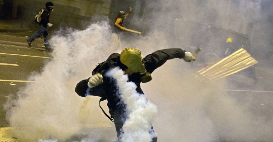 15.out.2013 - Manifestantes entram em confronto com a polícia após protesto de professores no Rio de Janeiro na noite desta terça-feira (15); ativistas usam máscaras contra os efeitos do gás lacrimogêneo