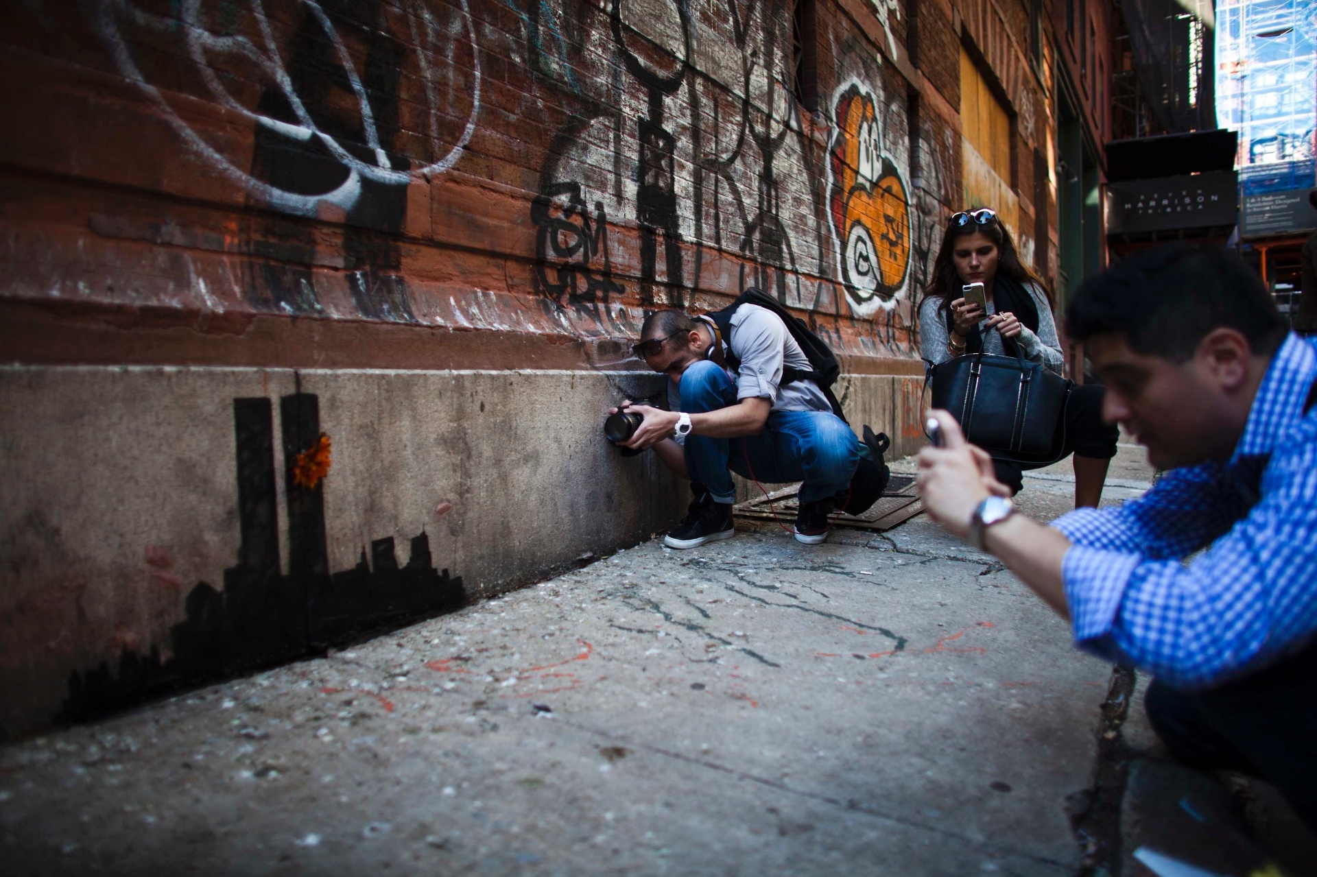 15.out.2013 - Pessoas se reúnem para olhar o novo trabalho do artista britânico Banksy em Lower Manhattan, em Nova York (EUA). No último fim de semana Banksy, cujo trabalho deverá render mais de US $ 150.000 em um leilão no final deste ano, vendeu pinturas em uma tenda no Central Park por US $ 60 - Eduardo Munoz/Reuters