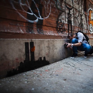 15.out.2013 - Pessoas se reúnem para olhar o novo trabalho do artista britânico Banksy em Lower Manhattan, em Nova York (EUA). No último fim de semana Banksy, cujo trabalho deverá render mais de US $ 150.000 em um leilão no final deste ano, vendeu pinturas em uma tenda no Central Park por US $ 60 - Eduardo Munoz/Reuters