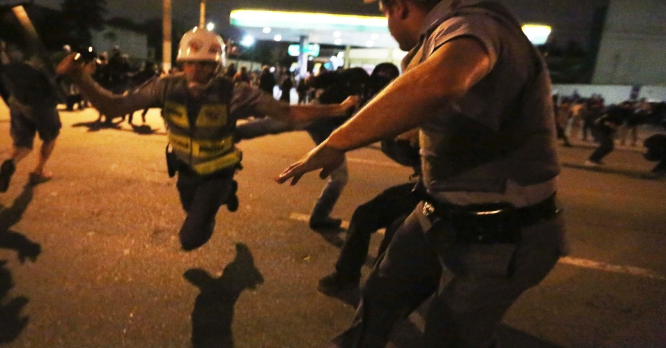 15.out.2013 - Policial militar cai ao ser chutado por manifestante durante profesto em São Paulo, nesta terça-feira (15), Dia do Professor