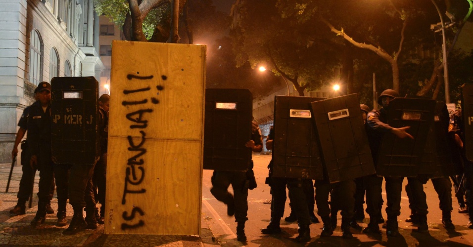 15.out.2013 - Policiais usam escudos para enfrentar manifestantes após protesto de professores no centro do Rio de Janeiro na noite desta terça-feira (15)