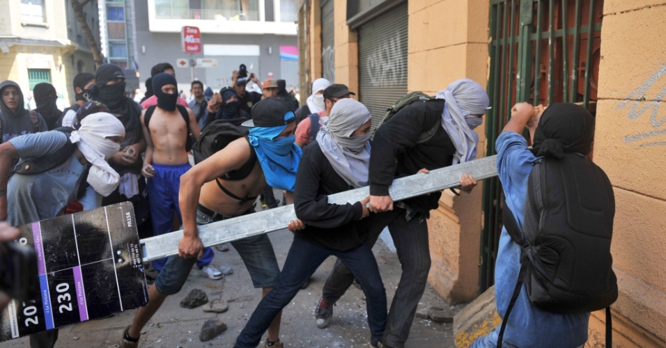 17.out.2013 - Estudantes tentam arrombar uma porta durante manifestação por melhorias no sistema público de educação chileno, em Santiago, nesta quinta-feira (17)
