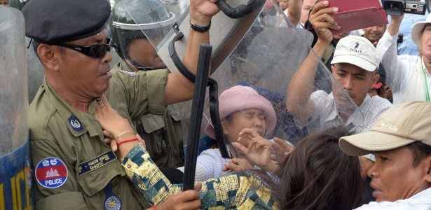 Polícia reprime manifestantes durante protesto em Phnom Penh. Ativistas do Camboja dizem que o governo já expropriou milhares de famílias de suas fazendas para ceder os terrenos a empresas privadas