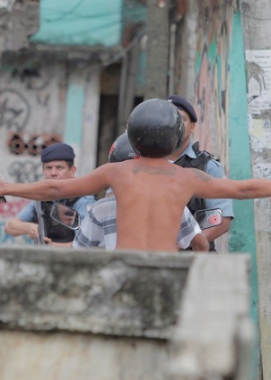 Policiais apontam armas para morador da comunidade de Manguinhos, na zona norte do Rio de Janeiro, durante protesto no dia 17 de outubro