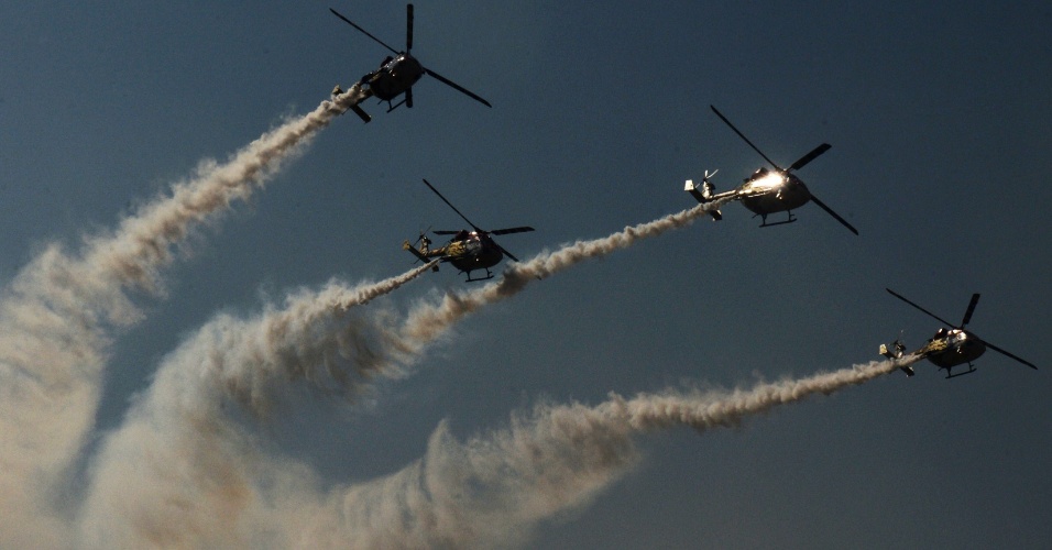 18.out.2013 - Equipe Sarang de helicópteros da Força Aérea Indiana voam em formação durante um show de acrobacias aéreas na sede do IAF em Srinagar, na Índia