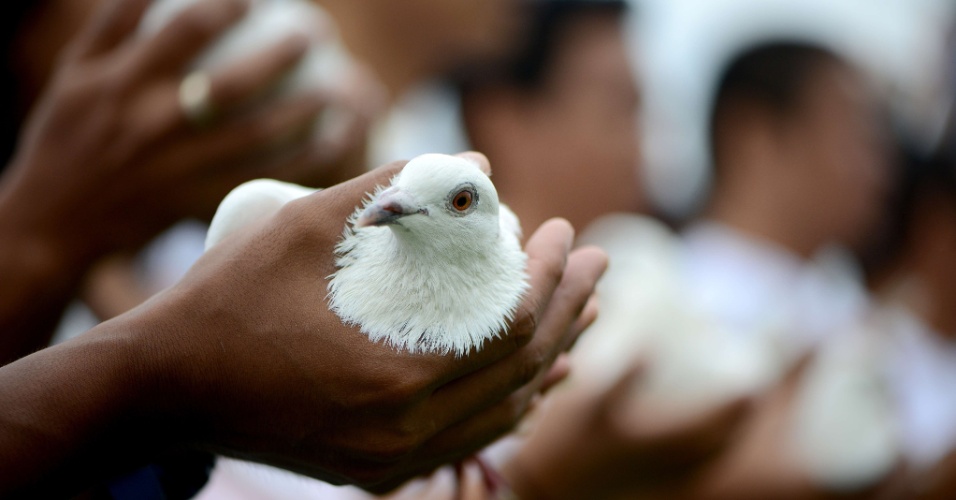 18.out.2013 - Membros do grupo ambiental Greenpeace soltam 30 pombas brancas para cada um dos "30" ativistas detidos em uma prisão russa, durante um protesto que marca o 30º dia de sua prisão, pedindo sua imediata libertação, em Manila, nas Filipinas