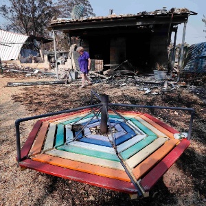 Moradora observa destroços de sua casa, que foi queimada por incêndio, no subúrbio de Winmalee, a 70 quilômetros de Sydney (Austrália) - David Gray/Reuters