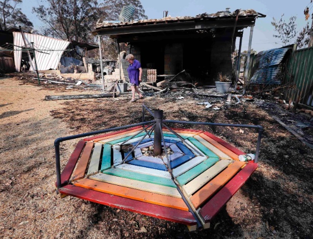 Moradora observa nesta segunda-feira (21) destroços de sua casa, que foi queimada por incêndio, no subúrbio de Winmalee, a 70 quilômetros de Sydney (Austrália)  - David Gray/Reuters