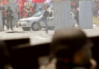 Manifestantes atacaram veículo em protesto contra o leilão do pré-sal, na Barra da Tijuca, no Rio; os militares reagiram com bombas de gás lacrimogêneo e balas de borracha - Julio Cesar Guimaraes/UOL