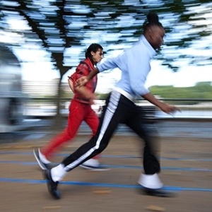 Ashiq Balush (de vermelho) durante a quebra do próprio recorde de Moonwalk de 20 metros mais rápido do mundo - Reprodução/Guinness