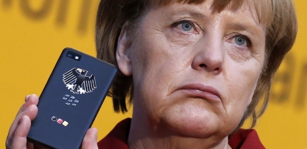 Merkel exibe aparelho celular com encriptador durante feira de informática. O telefone móvel da primeira-ministra teria sido grampeado pelos Estados Unidos  - Fabrizio Bensch/Reuters