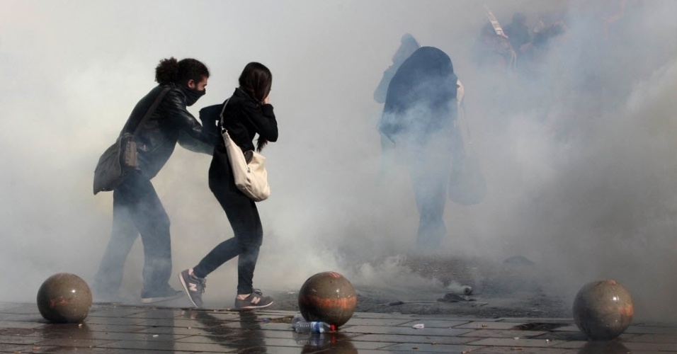 28.out.2013 - Manifestantes correm de bombas de gás lacrimogêneo lançadas pela polícia durante manifestação em Ancara, na Turquia, nesta segunda-feira (28). Os ativistas protestam contra a recusa da Justiça em prender policial acusado de ter matado manifestante em marcha em junho deste ano
