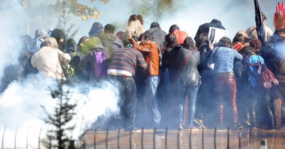 28.out.2013 - Manifestantes se protegem de bombas de gás lacrimogêneo lançadas pela polícia durante manifestação em Ancara, na Turquia, nesta segunda-feira (28). Os ativistas protestam contra a recusa da Justiça em prender policial acusado de ter matado manifestante em marcha em junho deste ano
